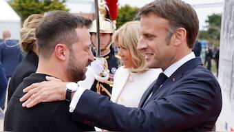 Ukrainian President Volodymyr Zelenskyy, left is greeted by French President Emmanuel Macron, at the international ceremony at Omaha Beach, near Saint-Laurent-sur-Mer. Thursday, June 6, 2024. - AP