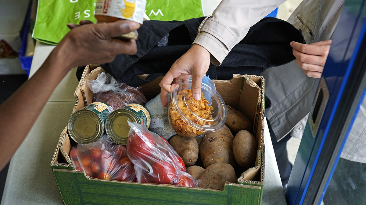 A woman, right, collects food at the Community Food Hub in Hackney, London, on 13 June, 2024. AP A woman, right, collects food at the Community Food Hub in Hackney, London, on 13 June, 2024. AP
