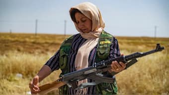 A volunteer in the Kurdish Community Protection Forces checks her rifle as she guards wheat fields from fire or looting around the town of Tarbesbeyeh, also known as al-Qahtaniyah in Arabic, in northeastern Syria's Hasakeh Governorate near the Turkish border. AFP
