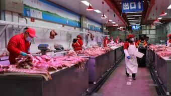 Vendors wearing face masks following the coronavirus disease (COVID-19) outbreak sell pork at the Xinfadi wholesale market in Beijing, China. Reuters file