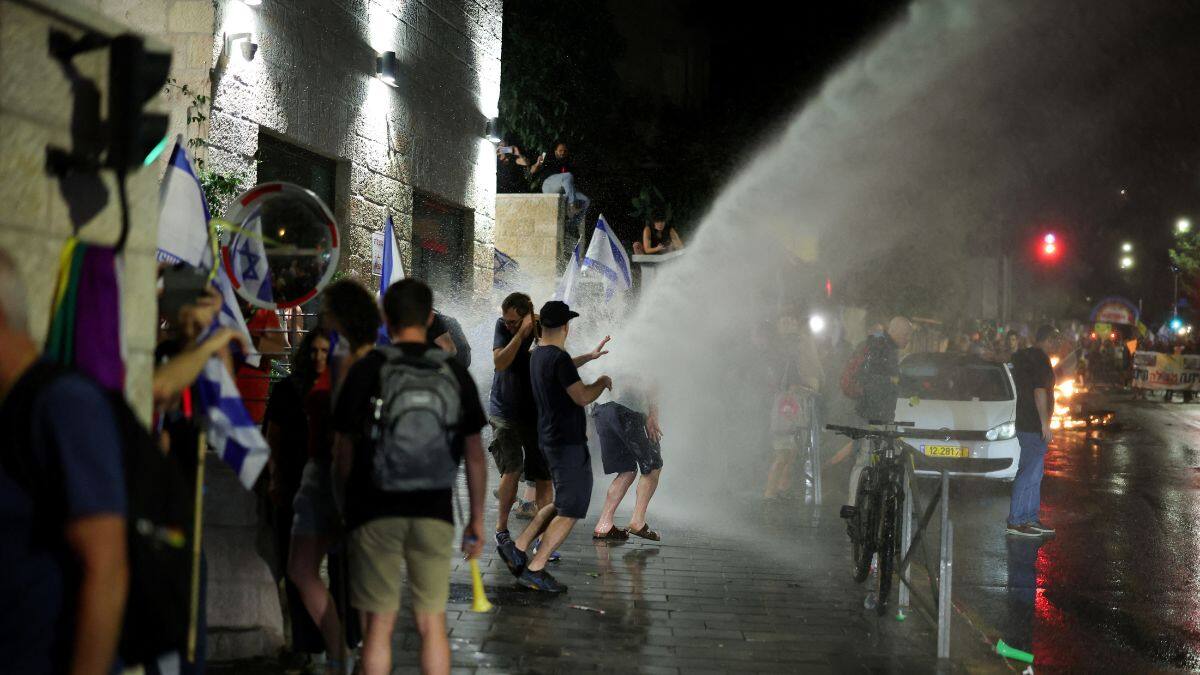 People are sprayed by a water cannon during a demonstration against Israeli Prime Minister Benjamin Netanyahu's government, near the Knesset, the Israeli parliament, in Jerusalem, 17 June, 2024. Reuters