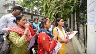 Aspirants search their roll numbers for seats before entering an examination centre to appear in the UGC-NET exam, at AN college in Patna, on 18 June. The exam has not been cancelled by the government. PTI