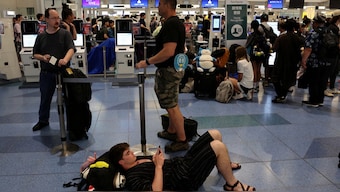 Louden Erskine, a US passenger waiting for a Delta Airlines flight, lies on the floor at Haneda International Airport, following a global IT outage, in Tokyo, Japan July 19,  2024. Reuters