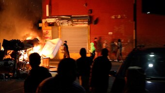 A man throws an item onto a fire during unrest in Harehills, Leeds, Britain, July 18, 2024. Reuters