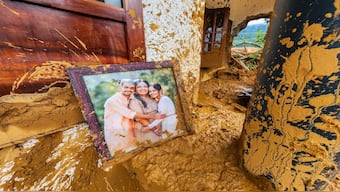 A framed photograph lies partially covered in mud at a damaged house after landslides hit hilly villages in Wayanad district, Kerala state, India, Tuesday, July 30, 2024. There was no immediate information available on the people in the picture. AP