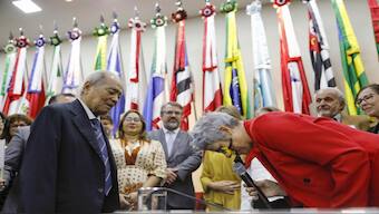 Eneá de Stutz e Almeida, right, president of the Amnesty Commission lowers her head as she apologizes in Brasilia, Brazil. AP