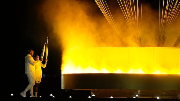  French gold medalists Teddy Riner and Marie-Jose Perec light the Olympic cauldron