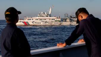 Members of the Philippine Coast Guard stand alert as a Chinese Coast Guard vessel blocks their way to a resupply mission at Second Thomas Shoal in the South China Sea. Reuters