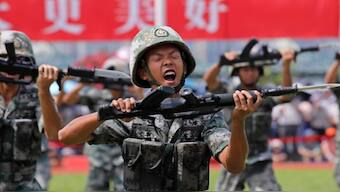 In this June 30, 2019, file photo, soldiers of Chinese People's Liberation Army demonstrate their skill during an open day of Stonecutter Island naval base, in Hong Kong. China is revising its National Defense Education Law to expand military training. AP File