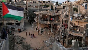 A Palestinian flag flies as the ruins of houses, which were destroyed by Israeli air strikes during the Israeli-Palestinian fighting, are seen, in Gaza Strip, May 25, 2021.  File Photo- Reuters