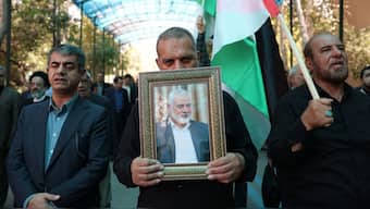 People hold up the Palestinian flag and a portrait of assassinated Hamas chief Ismail Haniyeh Hamas, during a rally at Tehran University, in the Iranian capital Tehran on July 31, 2024. Source: AFP.