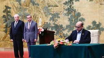 Senior member of Hamas, Mussa Abu Marzuk, right, signs a document as Chinese Foreign Minister Wang Yi, second left, and Vice Chairman of Fatah Mahmoud al-Aloul look on, at Diaoyutai State Guesthouse, Beijing, July 23, 2024. AP