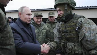 Russian President Vladimir Putin shakes hands with a soldier as he visits a military training centre of the Western Military District for mobilised reservists as Russian Defense Minister Sergei Shoigu, center, smiles in Ryazan Region, Russia, October 20, 2022. File Image/AP