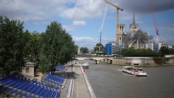 A tourists boat makes its way on the Seine river with stands installed on its banks in Paris. The Seine river will host the Paris Olympic Games opening ceremony on July 26. AP