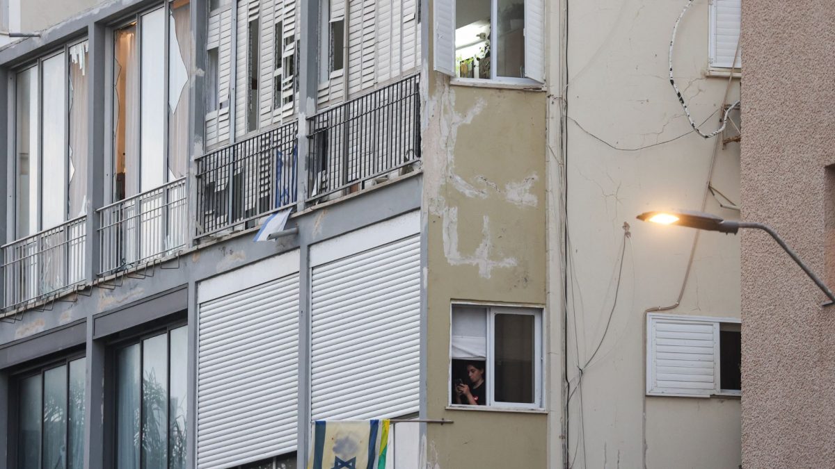 A woman stands near the window of an apartment as Israeli policemen search the scene where an explosion took place in Tel Aviv on July 19, 2024. Source: AFP. A woman stands near the window of an apartment as Israeli policemen search the scene where an explosion took place in Tel Aviv on July 19, 2024. Source: AFP.