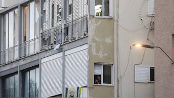 A woman stands near the window of an apartment as Israeli policemen search the scene where an explosion took place in Tel Aviv on July 19, 2024. Source: AFP.