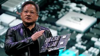 NVIDIA CEO Jensen Huang with a one of the company's AI processors. Image Credit: Reuters