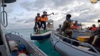 In this handout image provided by Armed Forces of the Philippines, Chinese Coast Guard hold knives and machetes as they approach Philippine troops on a resupply mission in the Second Thomas Shoal at the disputed South China Sea on June 17, 2024. AP