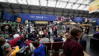 Travellers wait at the Gare de L'Est at the 2024 Summer Olympics, Friday, July 26, 2024, in Paris, France. Hours away from the grand opening ceremony of the Olympics, high-speed rail traffic was severely disrupted. AP