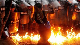 A demonstrator reacts when Molotov cocktails hit the ground in front of security forces during protests against election results after Venezuela's President Nicolas Maduro and his opposition rival Edmundo Gonzalez claimed victory in presidential election, in Puerto La Cruz, Venezuela. Reuters