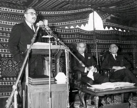 Abdus Salam delivers a speech, at the right side is sitting Prime Minister of Pakistan, Zulfiqar Ali Bhutto. Source: AhmadiyyaGallery.org