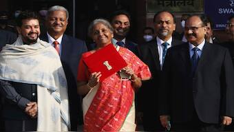 Finance Minister Nirmala Sitharaman holds up a folder with the Government of India logo, as India's Chief Economic Advisor Krishnamurthy Subramanian and Minister of State for Finance and Corporate Affairs Anurag Thakur look on as she leaves her office to present the budget in 2021. File image/Reuters