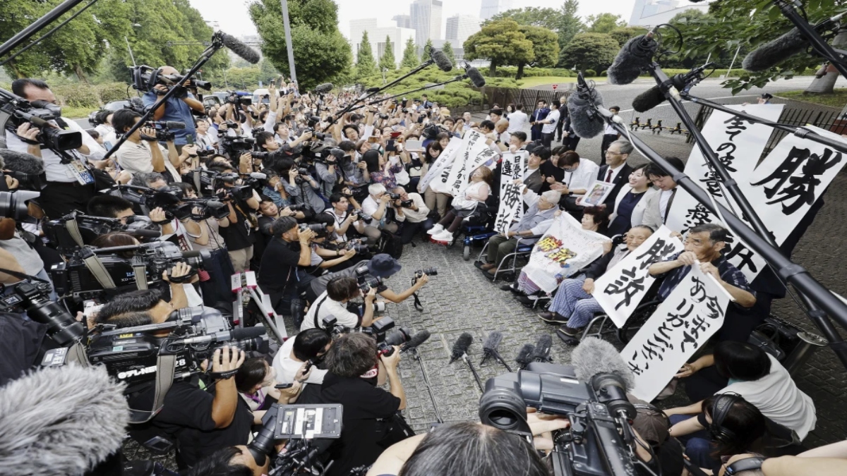 The plaintiffs, their lawyers and supporters hold the signs reading “Winning lawsuit” outside the Supreme Court after in Tokyo. Source: AP The plaintiffs, their lawyers and supporters hold the signs reading “Winning lawsuit” outside the Supreme Court after in Tokyo. Source: AP