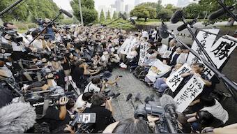 The plaintiffs, their lawyers and supporters hold the signs reading “Winning lawsuit” outside the Supreme Court after in Tokyo. Source: AP