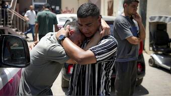 Palestinians mourn relatives killed in the Israeli bombardment of the Gaza Strip, at a hospital morgue in Deir al-Balah, on July 9. AP