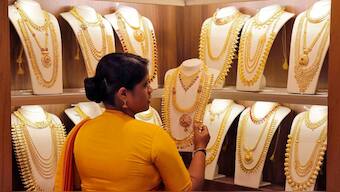 A saleswoman picks gold necklaces to show it to a customer inside a jewellery showroom in Kochi. Source: REUTERS/FILE