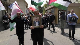 Members of Tehran University Council attend a protest to condemn the killing of Hamas leader Ismail Haniyeh, as they carry Iranian and Palestinian flags at the University in Tehran, Iran. AP
