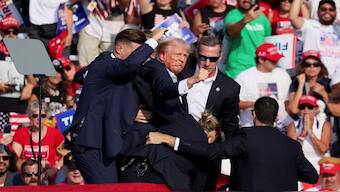 Republican presidential candidate and former US President Donald Trump is assisted by Secret Service personnel after gunfire rang out during a campaign rally at the Butler Farm Show in Butler, Pennsylvania. Reuters