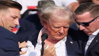 Republican presidential candidate and former US President Donald Trump is assisted by the Secret Service after gunfire rang out during a campaign rally at the Butler Farm Show in Butler, Pennsylvania. Reuters