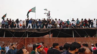 People waves Bangladeshi flags on top of the Ganabhaban, the Prime Minister's residence, as they celebrate the resignation of PM Sheikh Hasina in Dhaka, Bangladesh, August 5, 2024. Reuters