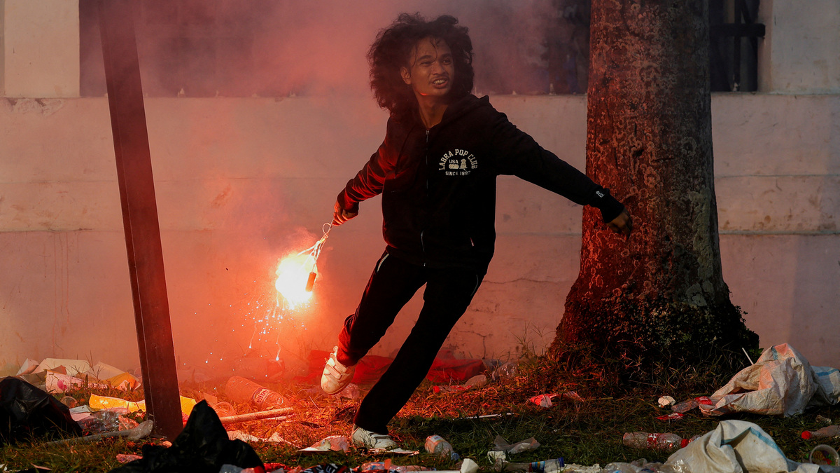 A demonstrator throws a flare as they clash with riot police during a protest against planned controversial revisions to election law outside the Indonesian Parliament building in Jakarta. Reuters A demonstrator throws a flare as they clash with riot police during a protest against planned controversial revisions to election law outside the Indonesian Parliament building in Jakarta. Reuters