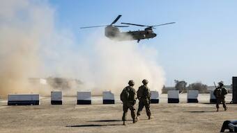 US troops walk as an army helicopter flies over the village of Oreij in Iraq, 22 February 2017. Photograph. File Image/ AFP