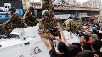 People shake hands with army personnel as they celebrate the resignation of Bangladeshi Prime Minister Sheikh Hasina in Dhaka, Bangladesh, August 5, 2024. File Image/Reuters
