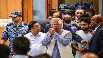 Nobel laureate Muhammad Yunus (C) greets journalists as he arrives for the press conference at the Hazrat Shahjalal International Airport in Dhaka on August 8, 2024. Image: Munir Uz Zaman / AFP