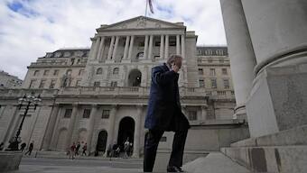 A man walks up the stairs in from of the Bank of England in London. AP