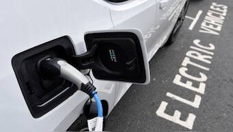 (File) An electric car is charged at a roadside EV charge point. Reuters