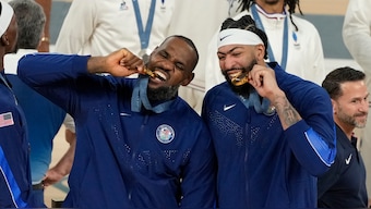 LeBron James and Anthony Davis bite their gold medals after helping USA defeat France in the men's basketball gold medal match at the Paris Olympics. AP
