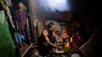 A man cooks dinner for his family in a shanty dwelling during lockdown to slow the spread of coronavirus infections in Yangon, Myanmar, October 21, 2020. File image/Reuters