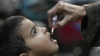 A health worker administers a polio vaccine to a child in Karachi, Pakistan. AP