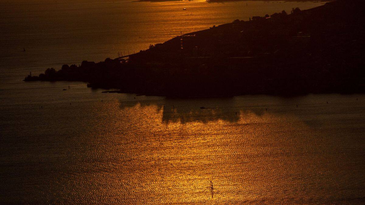 A windsurfer is pictured on Lake Leman during the sunset in Cully, Switzerland, August 19, 2024. File Image/Reuters