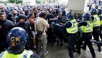 Police officers stand guard as counter-protesters push against the police cordon on the day of a protest against illegal immigration, in Bolton, UK, August 4, 2024. Reuters