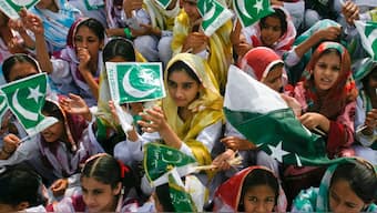 Female students wave Pakistan's national flag at a ceremony to celebrate Independence Day at the mausoleum of Muhammad Ali Jinnah in Karachi August 14, 2011. File Photo/Reuters