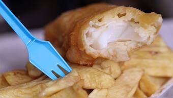 A plastic fork stands in a portion of fish and chips from a fish and chip shop is pictured in Manchester, Britain, May 18, 2022. File Photo/Reuters
