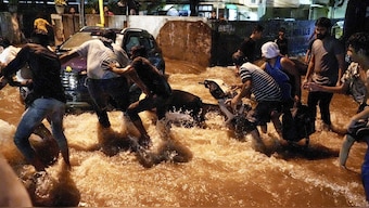 People try to pull a two-wheeler from being swept away by rainwater near Old Rajinder Nagar during the rain, in New Delhi, on Wednesday. PTI