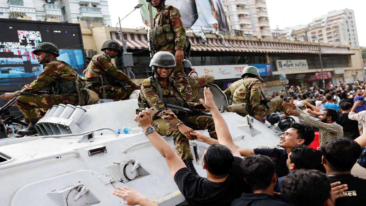 People shake hands with army personnel as they celebrate the resignation of Bangladeshi Prime Minister Sheikh Hasina in Dhaka, Bangladesh. Reuters People shake hands with army personnel as they celebrate the resignation of Bangladeshi Prime Minister Sheikh Hasina in Dhaka, Bangladesh. Reuters