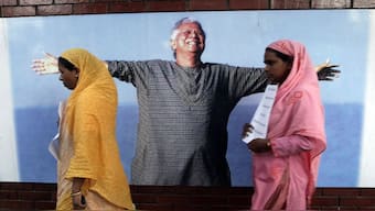 Employees of Grameen Bank walk in front of a portrait of Nobel laurate Muhammad Yunus in Dhaka. File image/Reuters